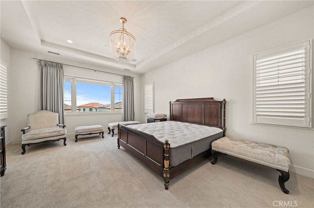 52 Eider Run Irvine, CA 92618 - Photo 40 of 46 a bedroom with a bed and a chandelier