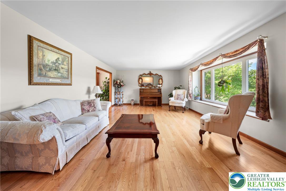 947 Tamenend Road Bath, PA 18014 - Photo 19 of 61 Natural light floods this inviting living space, highlighting its polished hardwood floors and serene atmosphere.