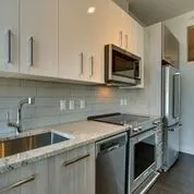 a kitchen with stainless steel appliances granite countertop a sink stove and microwave