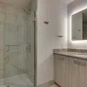 a bathroom with a granite countertop sink a mirror and shower