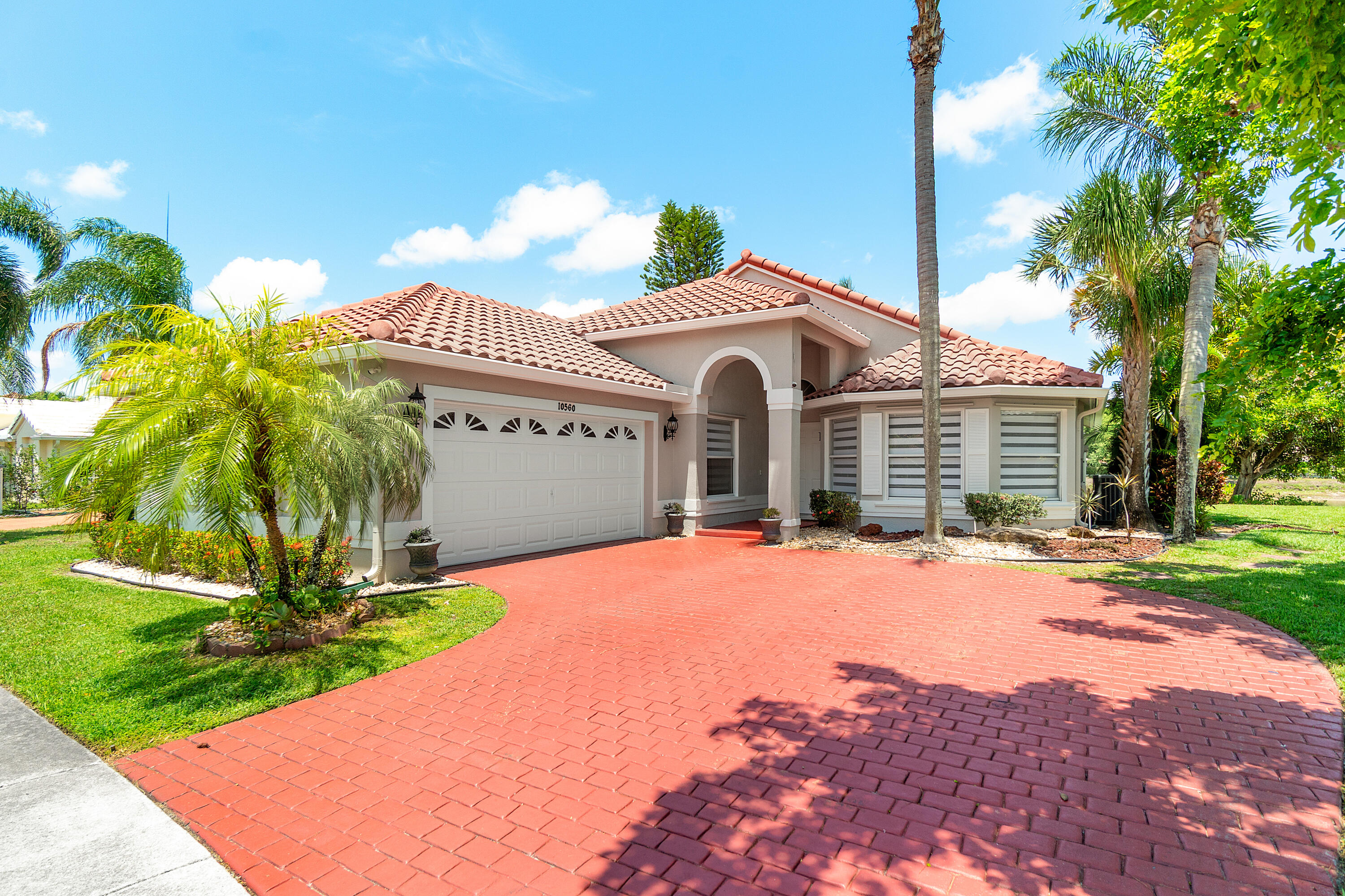 10560 Plainview Circle Boca Raton, FL 33498 - Photo 1 of 45 a front view of a house with a yard and garage