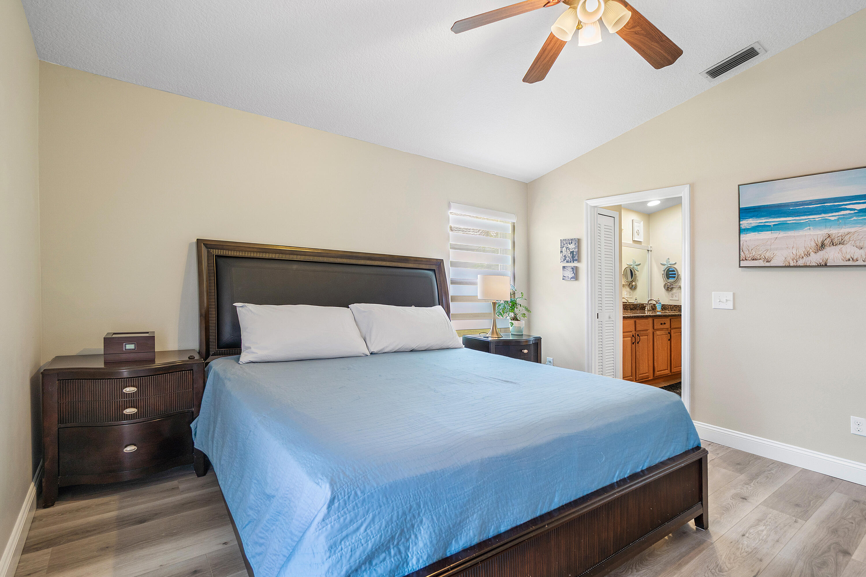 10560 Plainview Circle Boca Raton, FL 33498 - Photo 14 of 45 a bedroom with a large bed and a chandelier