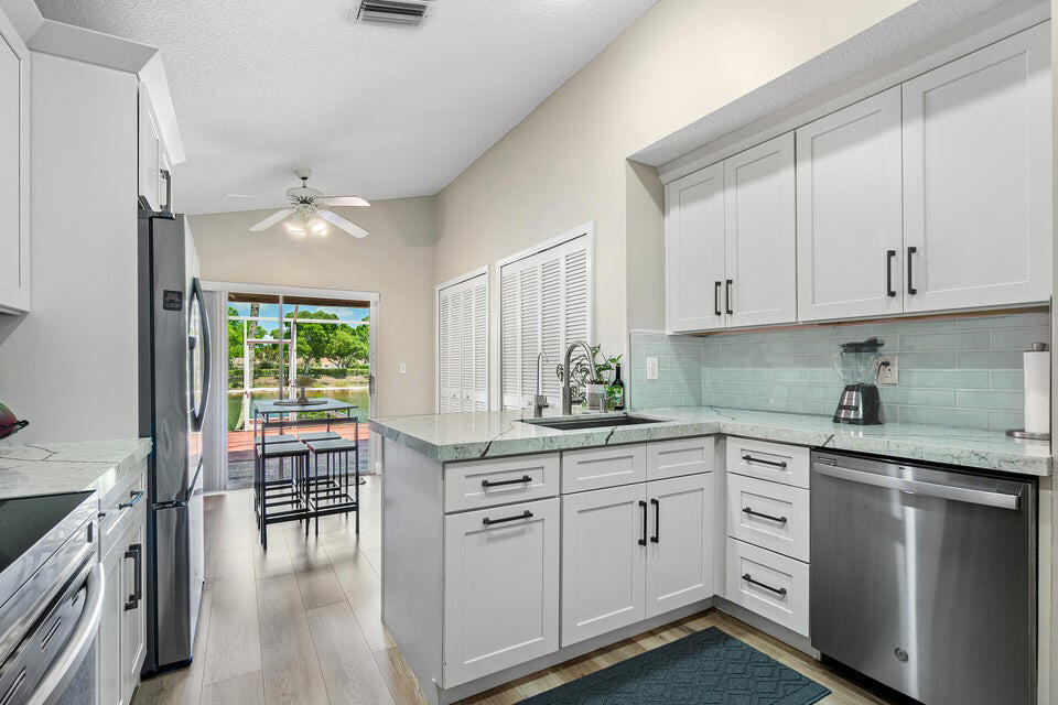 10560 Plainview Circle Boca Raton, FL 33498 - Photo 4 of 45 a kitchen with white cabinets and sink