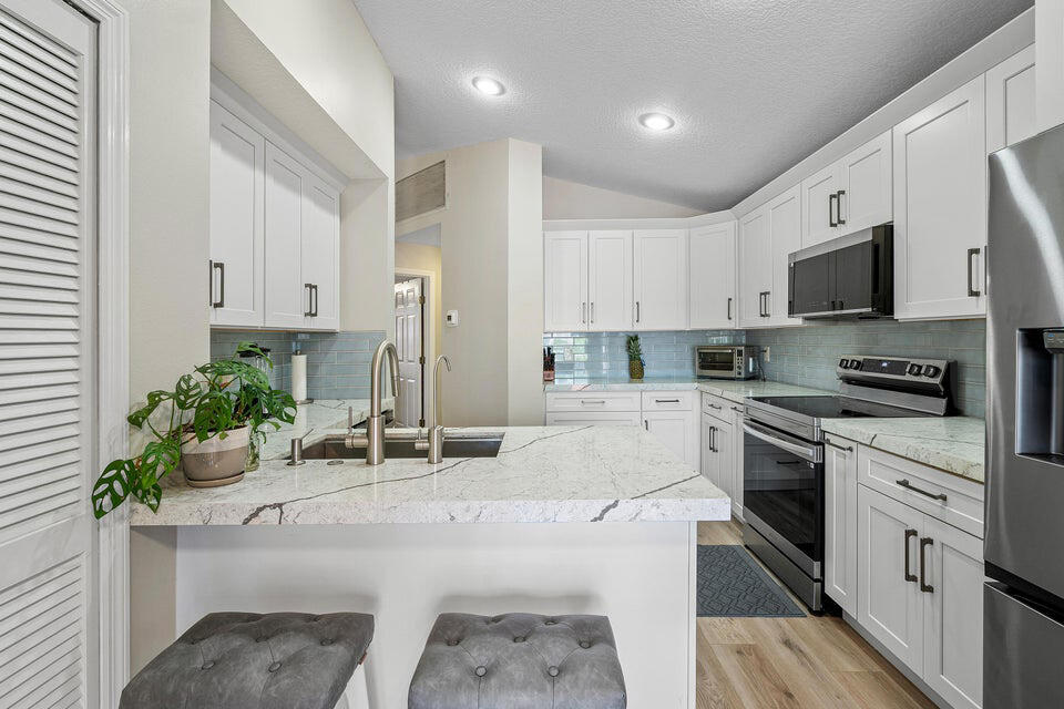 10560 Plainview Circle Boca Raton, FL 33498 - Photo 5 of 45 a kitchen with stainless steel appliances kitchen island granite countertop a sink and cabinets