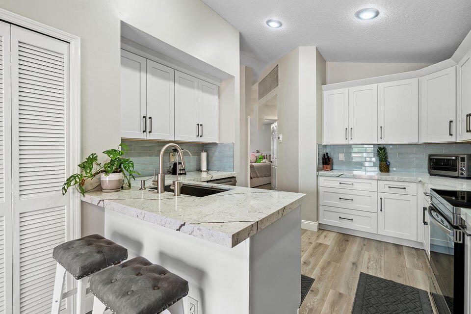 10560 Plainview Circle Boca Raton, FL 33498 - Photo 6 of 45 a kitchen with granite countertop a sink white cabinets and appliances