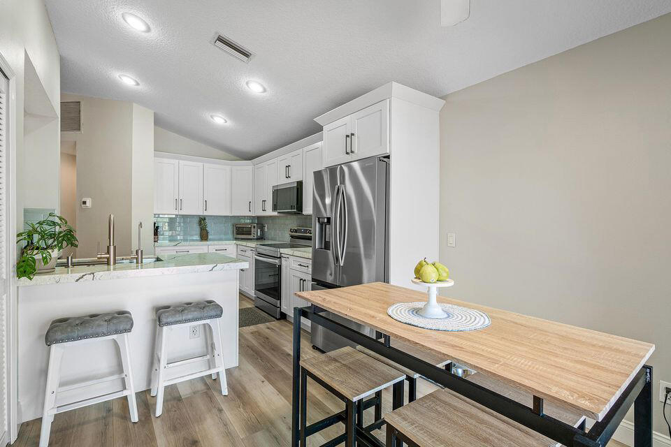 10560 Plainview Circle Boca Raton, FL 33498 - Photo 8 of 45 a kitchen with a table chairs stove and refrigerator
