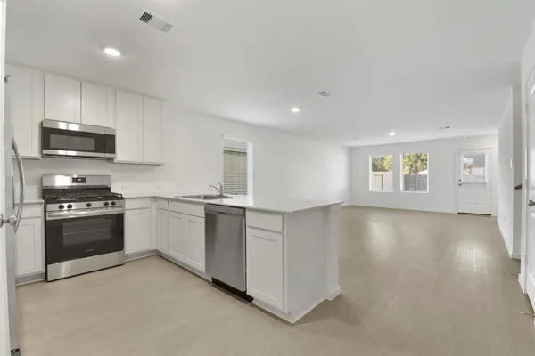a kitchen with stainless steel appliances granite countertop a stove a sink and a refrigerator