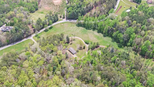 a view of a house with a lush green forest