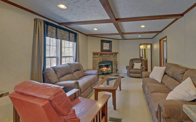 a living room with furniture a fireplace and a large window