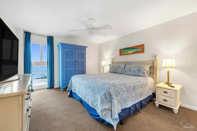 a bedroom with a bed and a flat tv screen on dresser