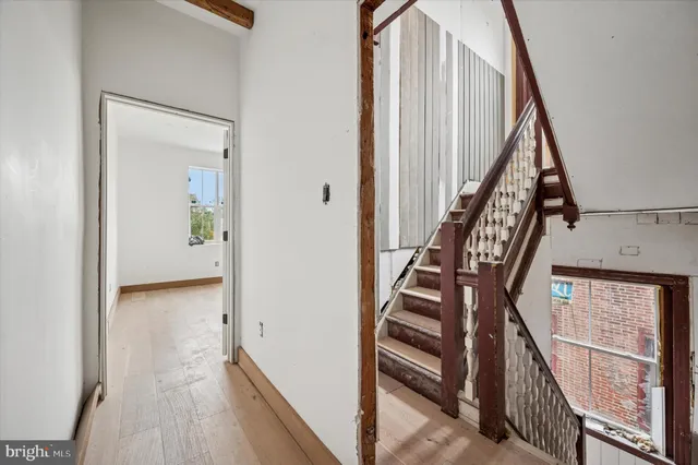 a large white kitchen with wooden floors and stainless steel appliances