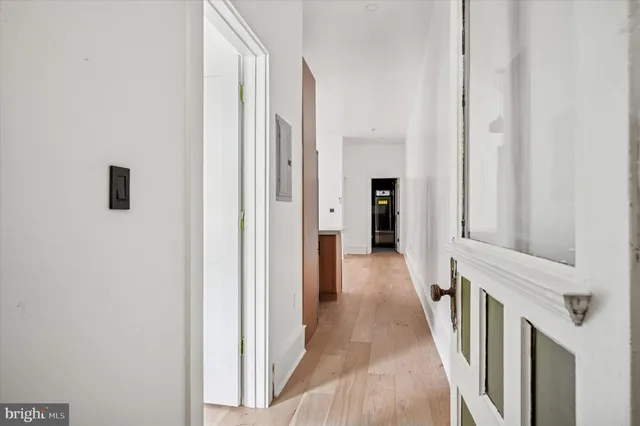 a view of a hallway with wooden floor and staircase