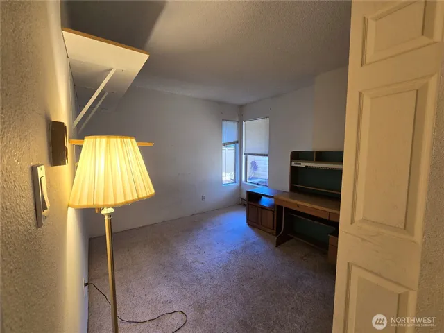 a living room with a table chair and piano