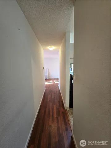 a view of a hallway with wooden floor and staircase