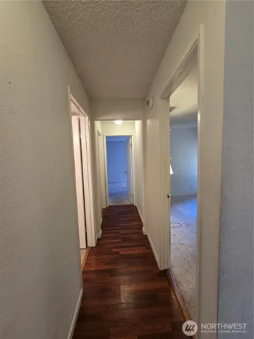 a view of a hallway with wooden floor and staircase