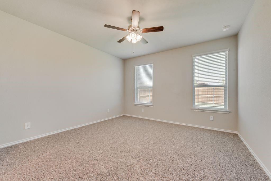 15944 Stableford Road Justin, TX 76247 - Photo 11 of 22 Spacious room featuring neutral carpeting, light-toned walls, and a ceiling fan with integrated lighting