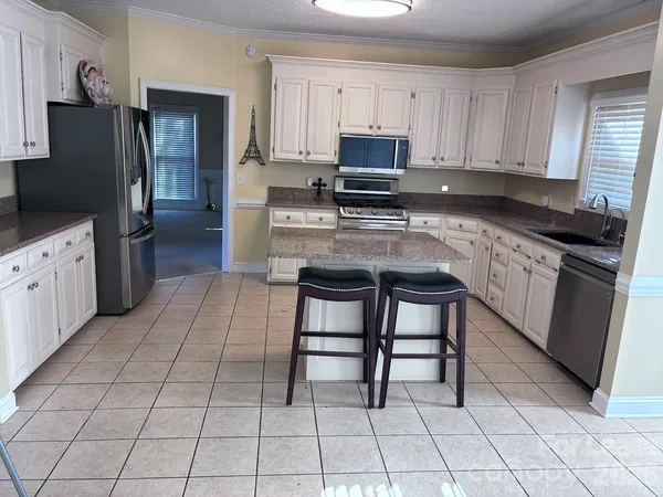 a kitchen with stainless steel appliances a stove a sink and a refrigerator