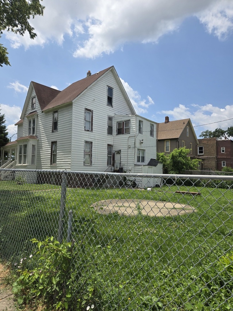 a view of a house with a big yard and large trees