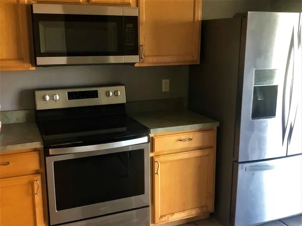a kitchen with stainless steel appliances white cabinets and a refrigerator