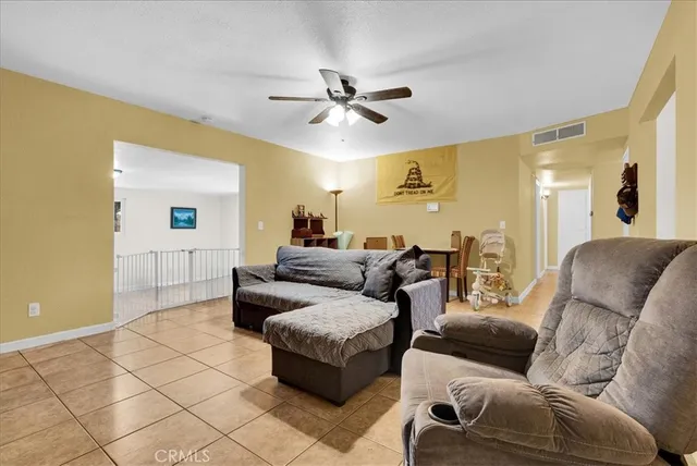 a living room with furniture and a ceiling fan