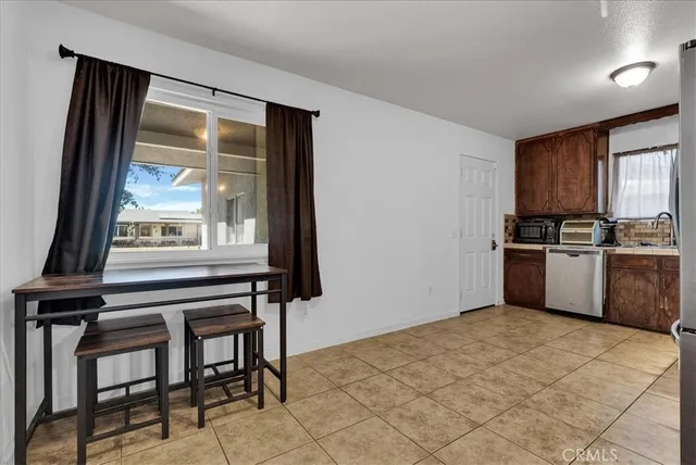 a kitchen with granite countertop a stove a sink and a refrigerator