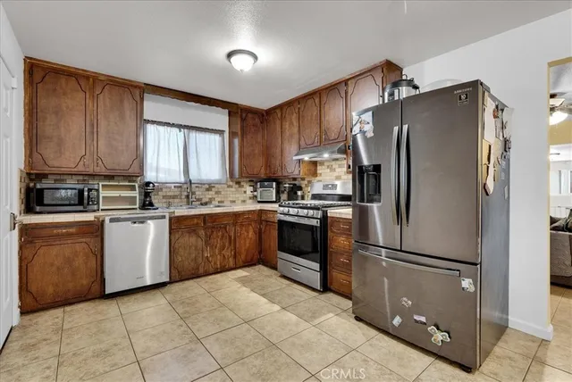 a kitchen with a refrigerator sink and cabinets