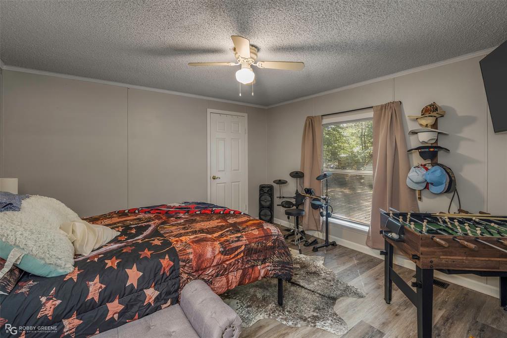 8273 Godfrey Road Shreveport, LA 71129 - Photo 19 of 27 Wood-finish flooring with a neutral wall color, white trim, and a ceiling fan with integrated lighting