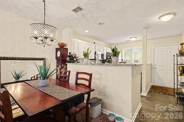 a living room with furniture kitchen view and a chandelier