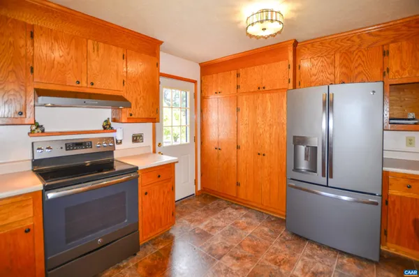 a kitchen with stainless steel appliances granite countertop a refrigerator a stove and a sink