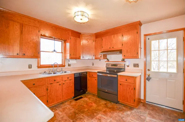 a kitchen with stainless steel appliances granite countertop a stove top oven a sink dishwasher and a refrigerator