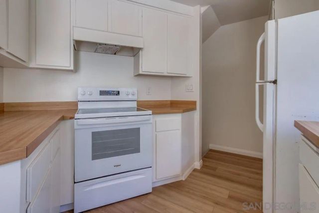 a kitchen with a stove cabinets and wooden floor