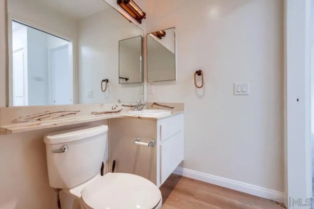 a bathroom with a sink toilet vanity and mirror