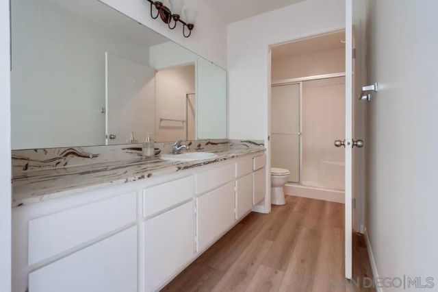 a bathroom with a sink a toilet and shower