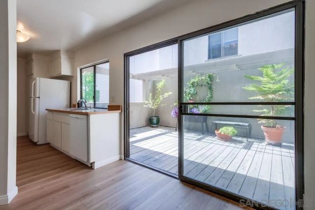 a view of a bedroom with wooden floor and a balcony