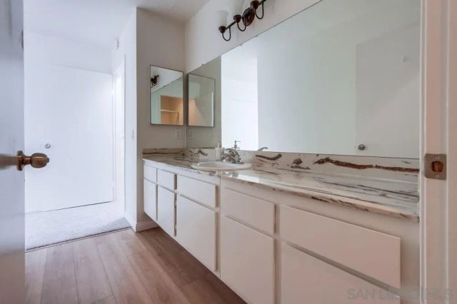 a bathroom with a granite countertop sink and a mirror