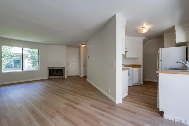 a view of open kitchen with wooden floor and electronic appliances