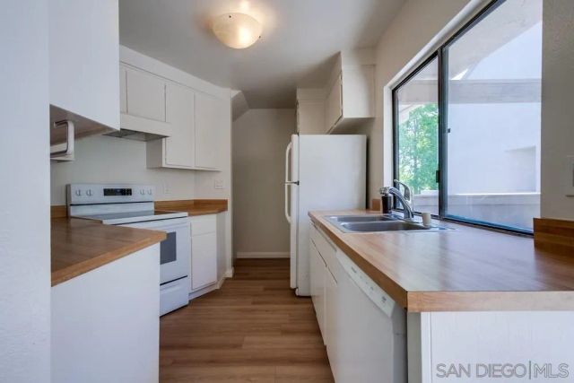 a kitchen with stainless steel appliances granite countertop a sink a stove and a refrigerator