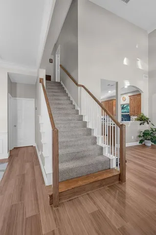 a view of staircase with wooden floor and white walls