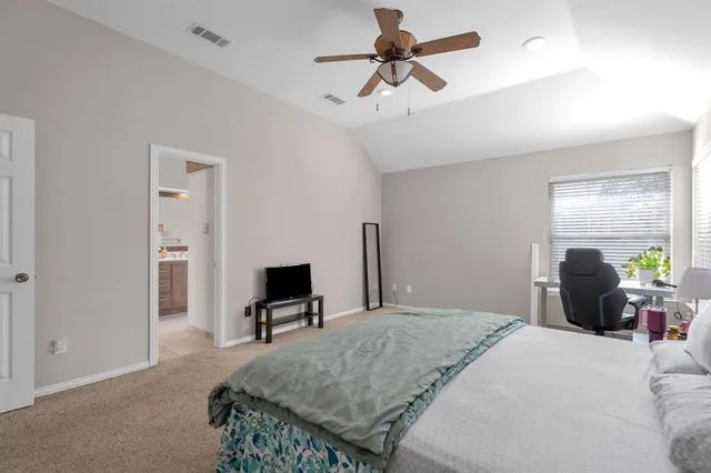 a bedroom with a bed a chandelier and dresser