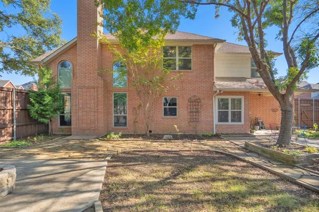 a view of a house with a yard and large tree