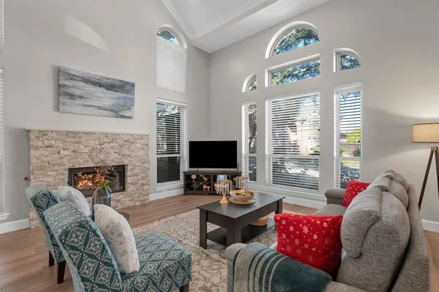 a living room with furniture fireplace and a large window