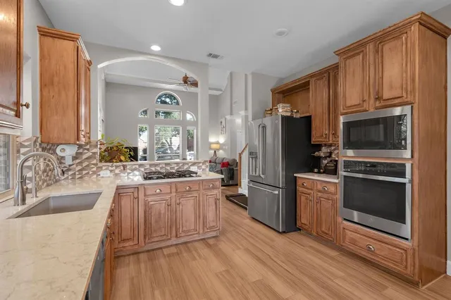 a kitchen with stainless steel appliances granite countertop a refrigerator stove and sink