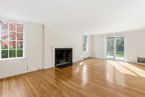 an empty room with wooden floor and fireplace