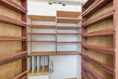 a view of walk in closet with empty racks
