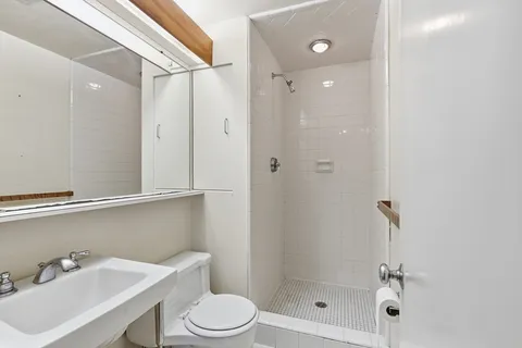 a bathroom with a shower a toilet and sink