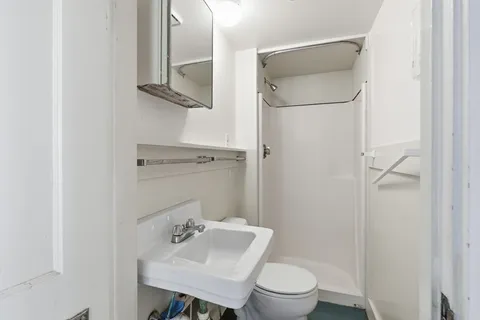 a bathroom with a sink toilet and a mirror