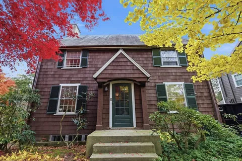a front view of a house with a garden