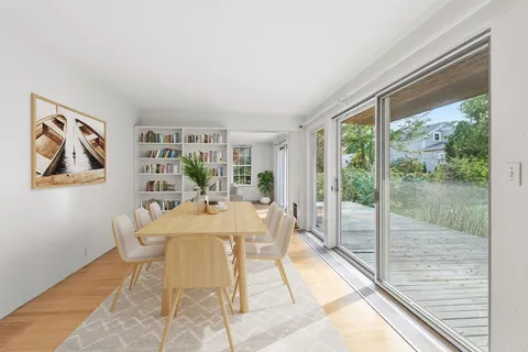 a dining room with furniture and a floor to ceiling window