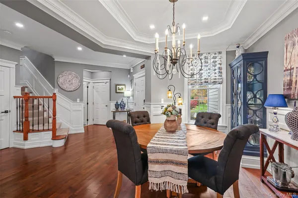 a view of a dining room with furniture a chandelier and wooden floor