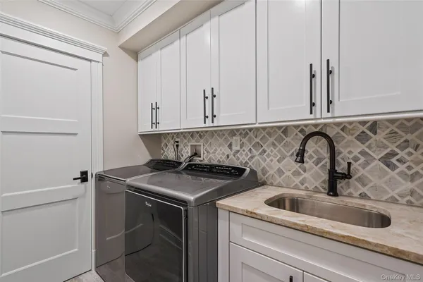 a kitchen with a sink stainless steel appliances and white cabinets
